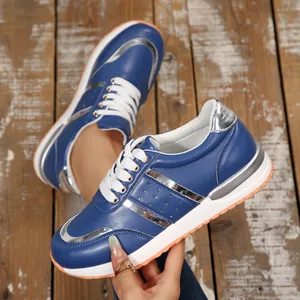Dettaglio di eleganti scarpe sportive in pelle blu con strisce metalliche argentate