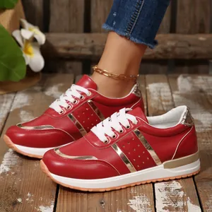 Dettaglio di sneakers rosse platform da donna con lacci bianchi e accenti dorati