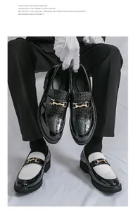 Détail de mocassins en cuir pour hommes avec texture crocodile et boucle dorée.