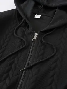 Close-up of jacquard textured fabric on black zip-up hoodie with hood cords