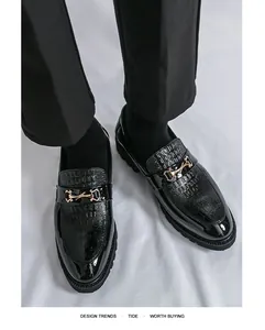 Gros plan de mocassins noirs vernis avec un élégant détail de boucle en métal doré.