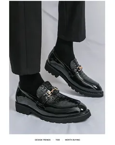 Gros plan de mocassins en cuir verni noir avec texture croco et boucle dorée