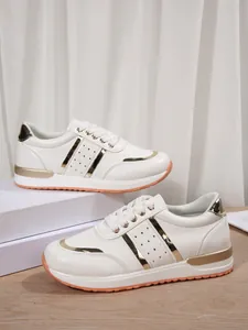 Vista dettagliata di sneaker bianche da donna con suola spessa e dettagli dorati
