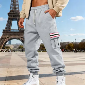 Stylish men's grey fleece cargo sweatpants with striped pockets and a Paris backdrop.