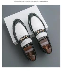 Détail de mocassins noir et blanc à motif crocodile avec boucle en métal doré