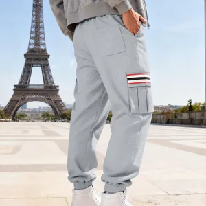 Detail showing the striped pocket flap on grey men's fleece cargo jogger pants.
