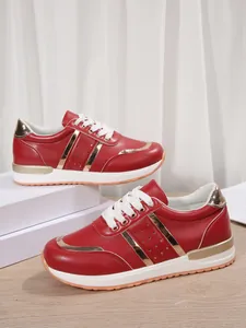 Vista laterale di sneaker rosse e oro con plateau e lacci bianchi in esposizione