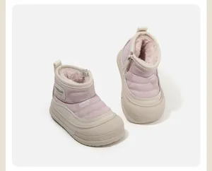 Vista detallada de botas de invierno rosas para niños con forro de piel y suela gruesa.