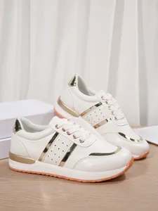 Vista laterale dettagliata di scarpe sportive bianche con dettagli dorati e suola spessa.
