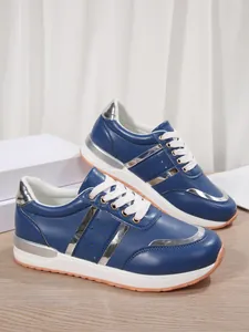 Dettaglio laterale di scarpe da ginnastica blu con plateau e inserti metallici