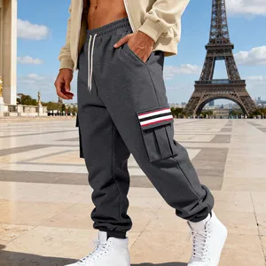 Macro detail of dark grey fleece cargo joggers for men with red and white striped pocket trim