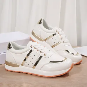 Profilo di sneakers bianche con plateau con eleganti dettagli in oro metallico.