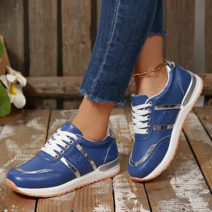 Vista laterale dettagliata di sneaker blu da donna con zeppa e strisce argentate