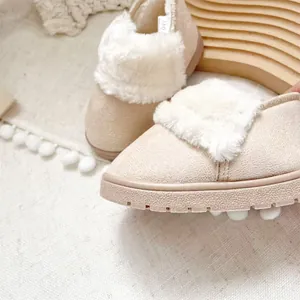 Detaillierte Nahaufnahme von beige Baby-Schneestiefeln mit flauschigem weißem Pelzkragen