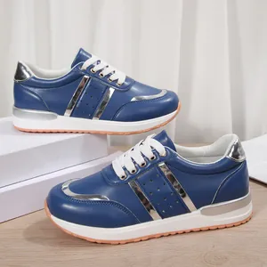 Vista dettagliata di sneaker blu da donna con inserti argento e spessa suola bianca