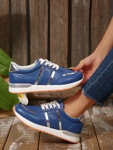 Vista dettagliata delle sneakers blu da donna con lacci e accenti metallici argento