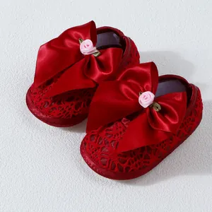 Elegant red baby princess shoes with large satin bows and lace detailing for infants.