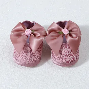 Adorable pink lace baby girl princess shoes with large satin bow and decorative rose flower