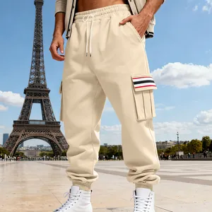 Detailed view of men's beige fleece cargo joggers with multi-pocket striped design