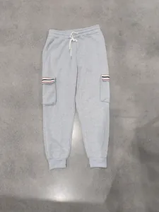Detail of men's grey fleece cargo joggers featuring striped pocket flaps and drawstring waist.