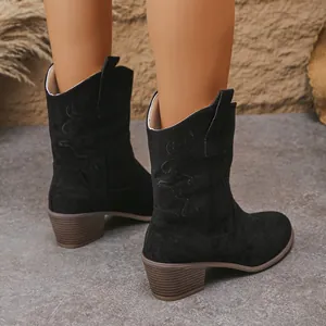 Detailed view of black suede Western cowboy boots with embroidered V-cut and chunky heels