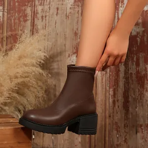 Vista lateral de botines Chelsea marrones para mujer con tacón ancho y suela plataforma
