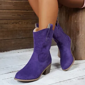 Detail view of purple suede western boots with embroidered patterns and chunky heels.