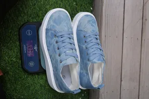 Gedetailleerde gewichtsmeting van lichtblauwe denim platform sneakers op een digitale weegschaal