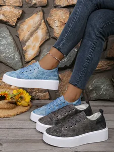 Detailweergave van denim sneakers met plateauzool in blauw en grijs met witte zool.