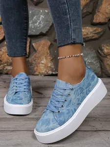 Close-up van blauwe denim platform sneakers voor dames met veters en ronde neus