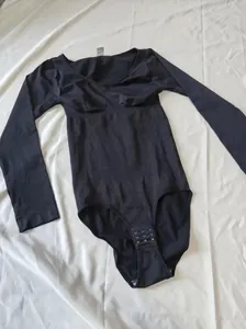 Vista completa di un body modellante nero a maniche lunghe con controllo pancia e ganci.