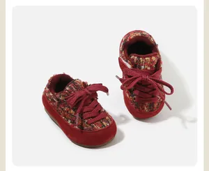 Détail des chaussures de marche d'hiver pour bébé en tweed tricoté rouge et daim