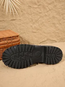 Détail de la semelle noire antidérapante en caoutchouc robuste de ces bottines Martin pour femmes