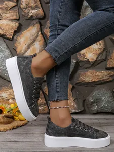 Detail van dames sneakers met platform van donkere denim en dikke witte zool.