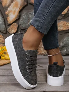 Gedetailleerde close-up van casual denim platform sneakers voor dames op houten vloer