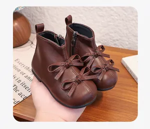 Detailed view of brown toddler girls' ankle boots with cute bow accents and soft soles.