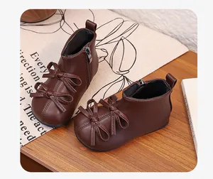 Close-up of brown toddler girl boots with elegant double bows and a side zipper closure