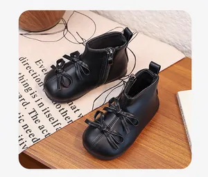 Close-up detail of black toddler girls boots featuring two bows and a side zipper closure.