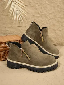 Vue détaillée de bottines en daim vert olive avec fermeture éclair dorée et semelle crantée