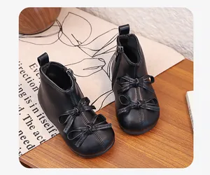 Close-up of black toddler girl boots with elegant bow-knot details and soft leather finish