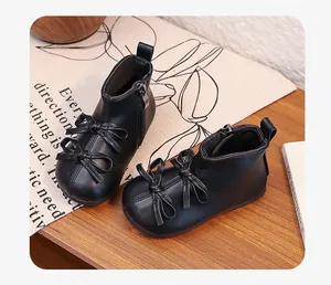 Close-up of elegant black toddler girl boots with bow decor and side zipper detail