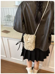 Model wearing a cozy curly faux fur crossbody phone bag in a warm kitchen setting