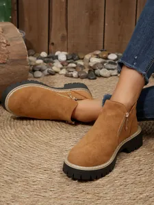 Vue latérale de bottines en daim avec fermeture éclair en métal et semelle crantée