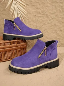 Vue détaillée de bottines en daim violet avec fermeture éclair dorée et semelle crantée