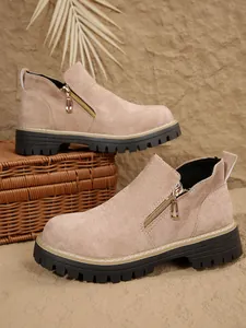 Vue latérale de bottines en daim beige avec fermeture éclair dorée et semelle plateforme noire.