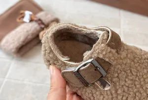 Κοντινό πλάνο καφέ γούνινα παπούτσια Birkenstock για παιδιά με μεταλλική αγκράφα