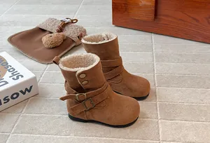 Detailed view of brown suede-like girls' boots with warm fleece lining and buckles