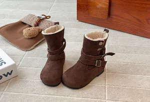 Detailed macro view of brown girls winter boots featuring soft cream faux fur lining
