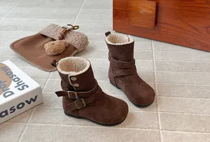 Detail of girls' brown suede winter boots with plush fleece lining and metal buckles.