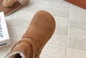 Macro view of brown suede girl's winter boots showing warm faux fur lining and buckle